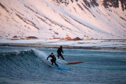 Dos personas hacen surf en la playa de Flackstad.