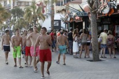 A group of English tourists walk through the town.