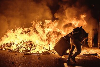 A pro-independence protester carries an object past a burning barricade during clashes that erupted after the Supreme Court sentenced nine Catalan separatist leaders to between nine and 13 years in prison over their roles in the 2017 breakaway attempt.