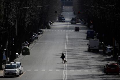 Una mujer pasea su perro por una calle de Roma, el lunes 23 de marzo.