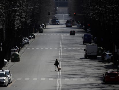 Una mujer pasea su perro por una calle de Roma, el lunes 23 de marzo.