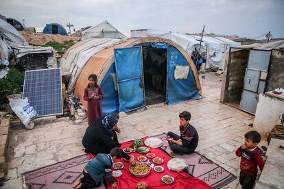 Displaced Syrians eat their first dinner to break this year's Ramadan fast at the Samavi refugee camp in Idlib, on March 23, 2023.