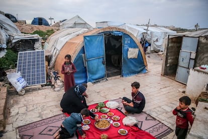 Displaced Syrians eat their first dinner to break this year's Ramadan fast at the Samavi refugee camp in Idlib, on March 23, 2023.