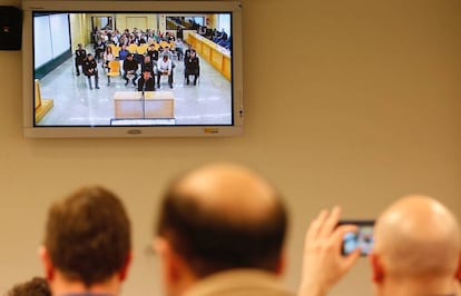 Varias personas miran en la pantalla el inicio del juicio de Alsasua, este lunes.