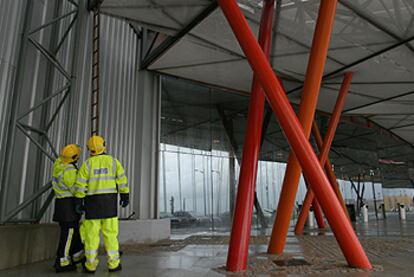 Dos bomberos, al pie de la escalera que usaron ayer para acceder al techo del Palacio de Ferias de Málaga.
