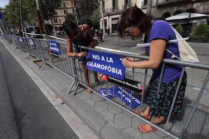 Dos jóvenes colocan una pancarta en el paseo de Gràcia de Barcelona contra la islamofobia, en una imagen de archivo.