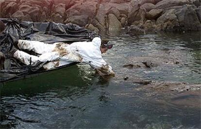 Un mariscador <b></b><i>de Santa Mariña (Camariñas, A Coruña) recoge el viscoso chapapote del Prestige</i> llegado ayer a la costa.