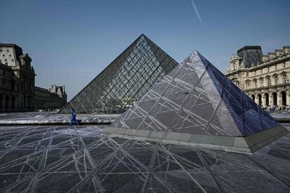 Cuando se publicó la maqueta Pei en 1984, hubo una 'explosión' de críticas, que denunciaban por ejemplo que el Louvre se convertiría en 'la casa de los muertos'. En la imagen, un voluntario caminando junto a las pirámides.
