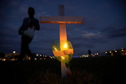 Integrantes de diversos movimentos sociais realizam um ato no que acendem as vai coladas a 400 cruzes, em em frente ao edifício do Congresso Nacional, como homenagem às 395.000 mortes por covid-19 que acumula o Brasil desde o começo da crise sanitária, faz pouco mais de um ano.