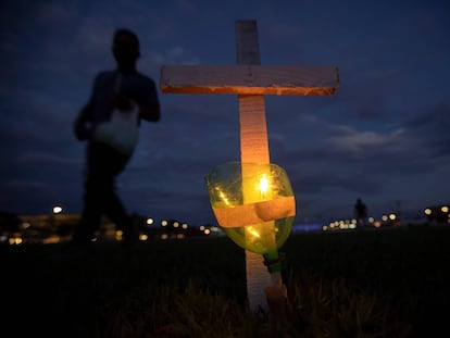 Integrantes de diversos movimentos sociais realizam um ato no que acendem as vai coladas a 400 cruzes, em em frente ao edifício do Congresso Nacional, como homenagem às 395.000 mortes por covid-19 que acumula o Brasil desde o começo da crise sanitária, faz pouco mais de um ano.