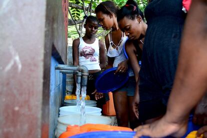 Un grupo de mujeres llena sus ‘bokits’, garrafas de 20 litros, en un kiosco de Jacmel.