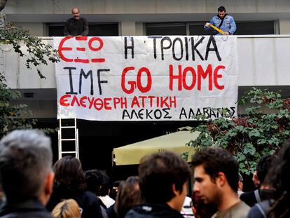 Un grupo de activistas cuelgan una pancarta que dice "fuera la troika" y "FMI, vete a casa" en un edificio de apartamentos donde representantes del FMI alquilaron sus oficinas, en Atenas el 4 de noviembre de 2010.