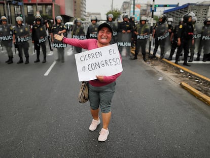 A protester carries a sign that reads “Close the Congress” during a demonstration, after the Peruvian government declared a state of emergency on December 15, 2022.