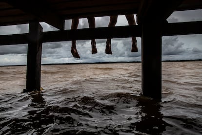 Un grupo de niños miran el río Amazonas durante la marea alta desde la plataforma frente a su pueblo Junco, justo al lado del canal Urucurituba.