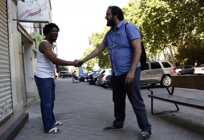 Guillermo Zapata saluda y charla con un habitante del barrio propietario de una peluquería.