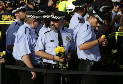 Policías de la guardia urbana con flores durante la protesta por los ataques.