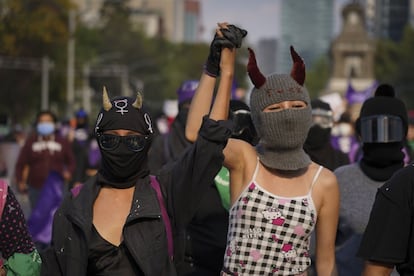 Dos mujeres avanzan sobre Reforma, con las manos entrelazadas y gritando consignas durante la marcha de este jueves.