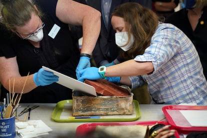 Sue Donovan, conservadora de Colecciones Especiales de la Biblioteca de la Universidad de Virginia, y Kate Ridgway, conservadora del Departamento de Recursos Históricos de Virginia, retiran uno de los tres libros encontrados en una cápsula del tiempo recuperada del monumento del general confederado Robert E. Lee en Richmond, Virginia.