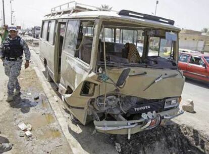 Un policía iraquí asegura la zona del atentado en Bagdad contra un minibús con peregrinos.