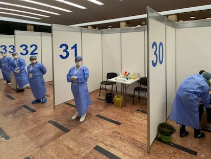 Un hombre recibe la vacuna de Pfizer mientras el personal médico espera a los pacientes en una sala de eventos en Bucarest, Rumanía.