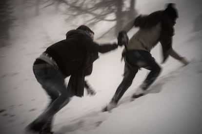 Dos personas se ayudan en su travesía por el valle de Montgenèvre, entre Italia y Francia (2019).