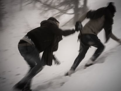 Dos personas se ayudan en su travesía por el valle de Montgenèvre, entre Italia y Francia (2019).