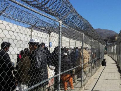 Una fila de personas espera para cruzar de Pakistán a Afganistán por el paso de Torkham.