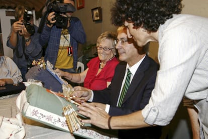 El presidente de Castilla-La Mancha, José María Barreda, aprende a hacer bolillos en una feria en Toledo.