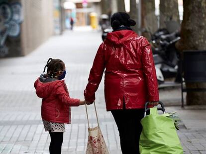 Una mujer y una niña caminan por el barrio de Gracia de Barcelona.