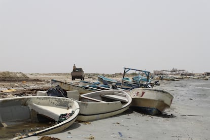 Un vehículo militar pasa antes barcazas dañadas en el litoral de Hajjah, en Yemen. 
