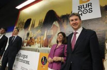 El alcalde de Burgos, Javier Lacalle (d), posa junto a uno de los carteles de promoción instalados en la estación de metro Gregorio Marañón de Madrid.