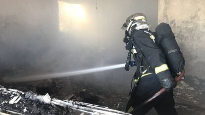 Los bomberos trabajan en el interior de la vivienda cuyo incendio costó la vida a un hombre de 88 años