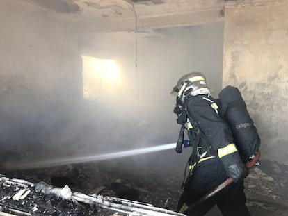 Los bomberos trabajan en el interior de la vivienda cuyo incendio costó la vida a un hombre de 88 años