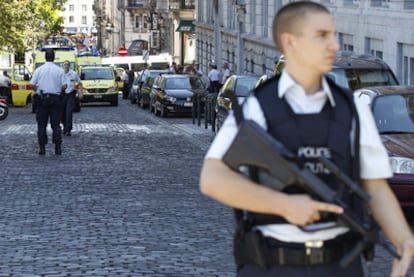 Un agente vigila en los alrededores del tribunal de paz de la capital belga, Bruselas, donde un hombre armado ha disparado hoy contra una juez y su secretario judicial, causando la muerte a ambos.