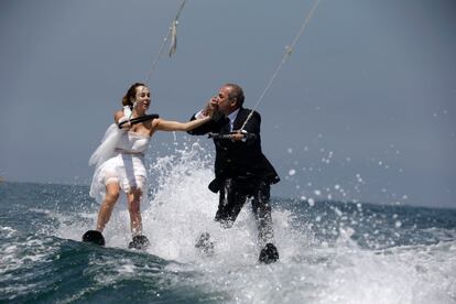 Una pareja de novios muestran su cariño mientras practican esquí acuático vestidos con sus trajes de boda en la bahía de Jounieh (Líbano), el 29 de mayo de 2017.