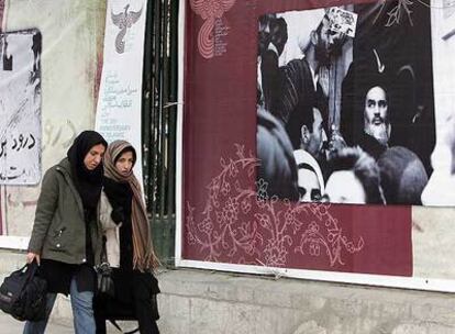 Dos mujeres pasan delante de un cartel conmemorativo del 30º aniversario de la revolución islámica.