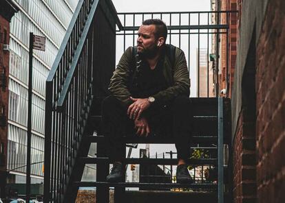 Hombre sentado en unas escaleras utilizando unos AirPods