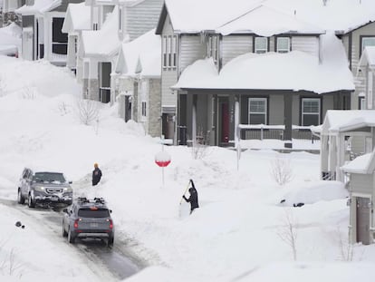 Cars try to make their way up and down a street as people try and dig out from feet of snow that fell in Draper, Utah, on February 23, 2023.