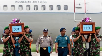 Militares transportam corpos de vítimas do voo QZ8501.