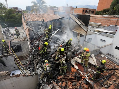 Bomberos trabajan en las casas donde se estrelló la avioneta en Medellín.