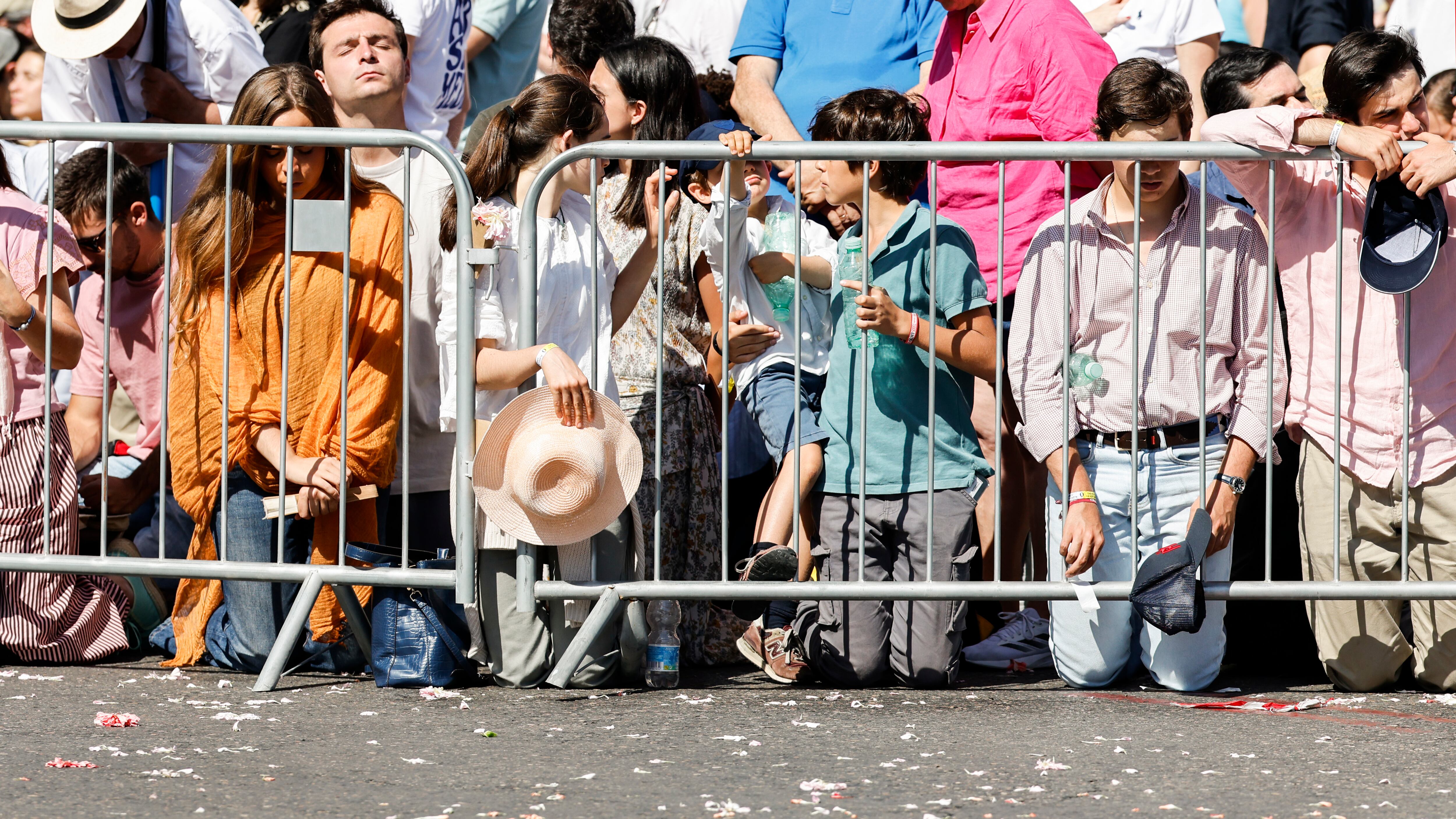 Fieles se arrodillan en el momento de la consagración, durante la misa que oficia el Papa en Cibeles este domingo.
