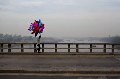 Un vendedor ambulante vende en un puente que cruza el río Buriganga a las afueras de Daca (Bangladés).