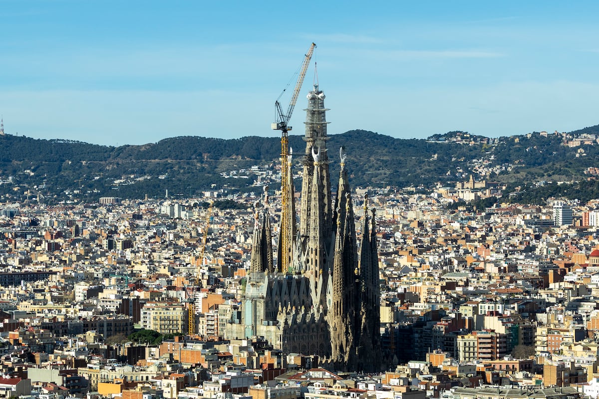 La Basílica de la Sagrada Familia corona su torre más alta y roza el cielo de Barcelona, en imágenes