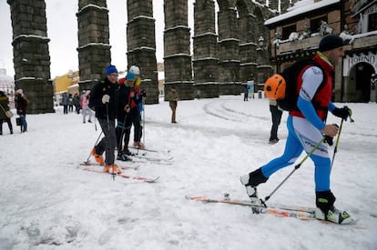 Un grupo de personas con esquís de fondo se desliza junto al Acueducto de Segovia donde la nieve ha superado los treinta centímetros.