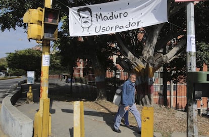Una tela en la que se puede leer "Maduro Usurpador" cuelga de un semáforo en Caracas (Venezuela).