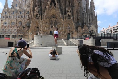 Varios turistas se hacen fotografías frente a la fachada del Naixement de la Sagrada Familia.
