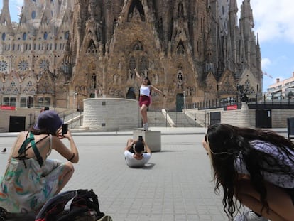 Varios turistas se hacen fotografías frente a la fachada del Naixement de la Sagrada Familia.