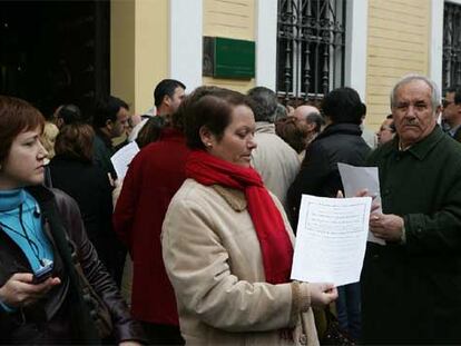 Propietarios de viviendas de VPO, ayer, ante la puerta de la Delegación de Obras Públicas en Sevilla.
