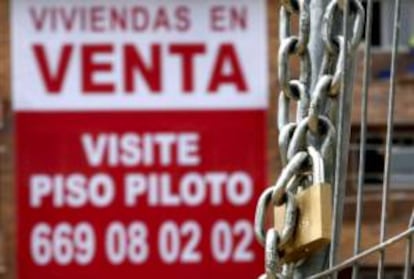 En la imagen, un cartel anunciador de venta pisos cuelga de una fachada de una nueva promoción en Madrid.