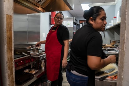 Ana Liz Pulido y Viridiana Candelario, trabajando en la cocina de la taquería. 